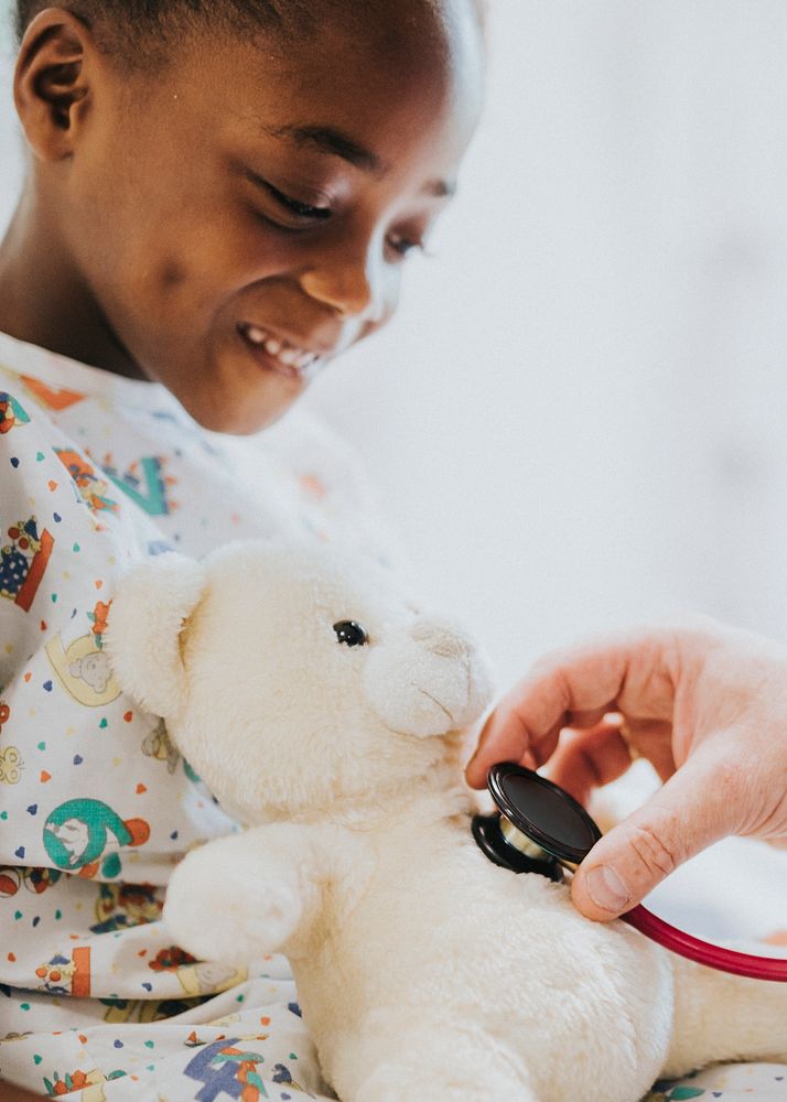 Pediatrician checking teddy bear's heart beat