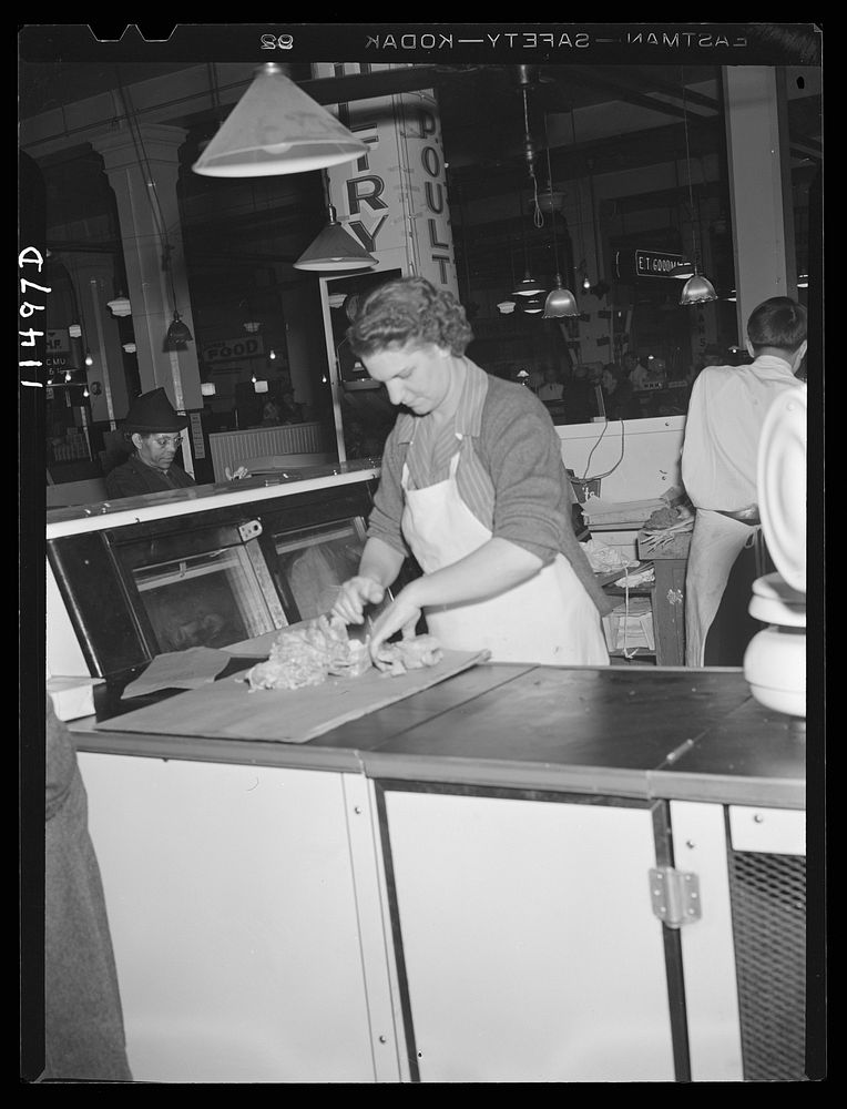 Washington, D.C. Woman wrapping a chicken for a customer in the Arcade Market on 14th Street, N.W.. Sourced from the Library…