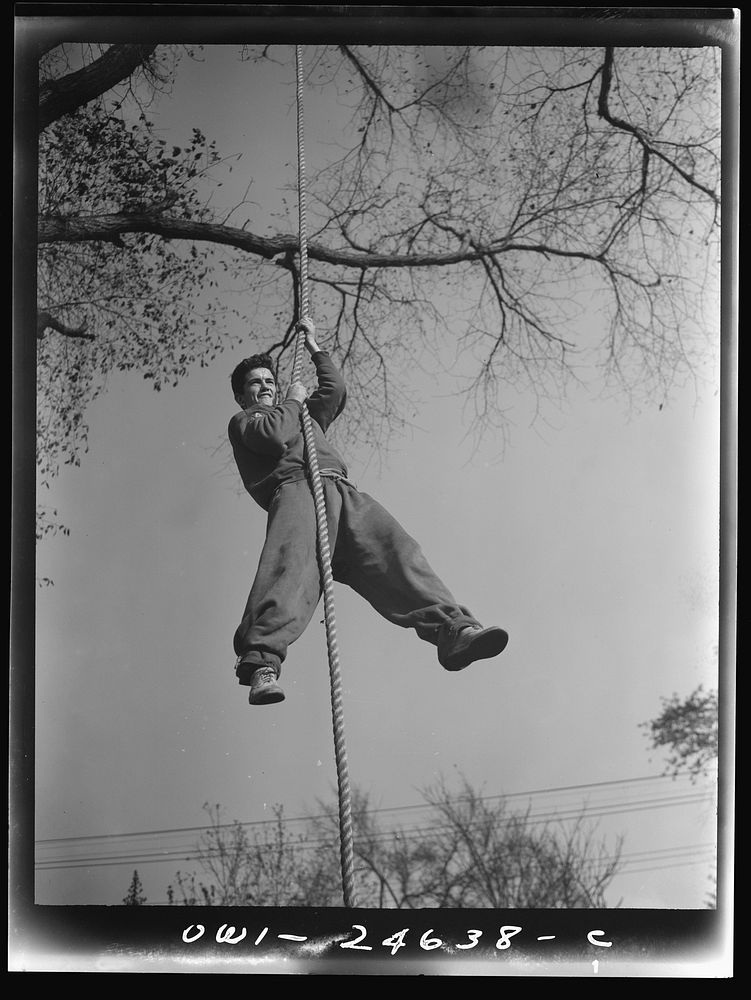 Flushing High School, Queens, New York. A high school boy climbing a rope during a "commando" course. Sourced from the…