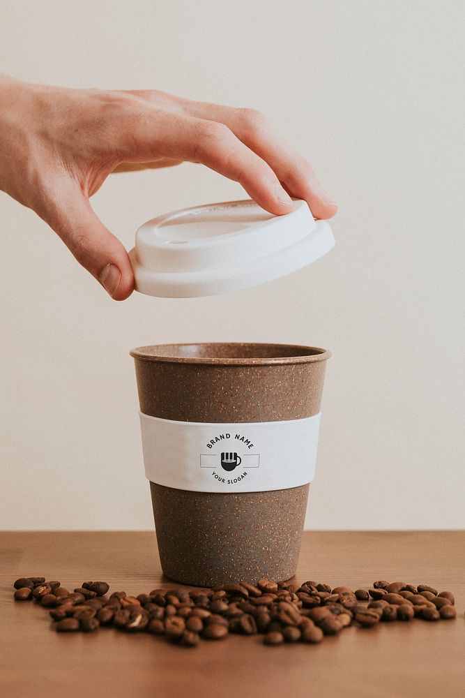 Hand opening a reusable coffee cup mockup