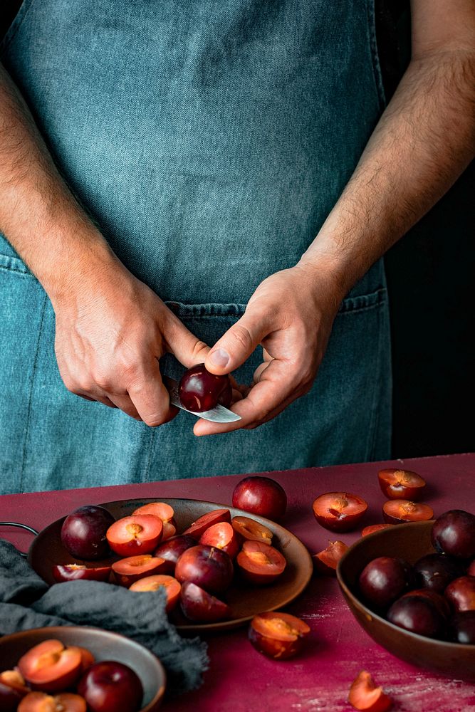 Man cutting plums in half