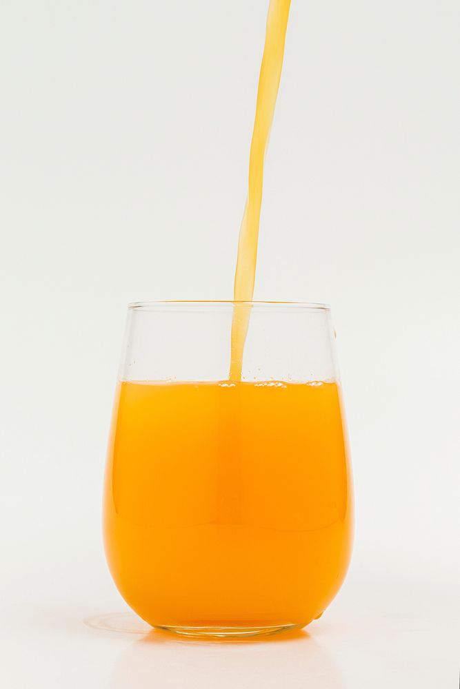 Pouring fresh organic orange juice into a glass