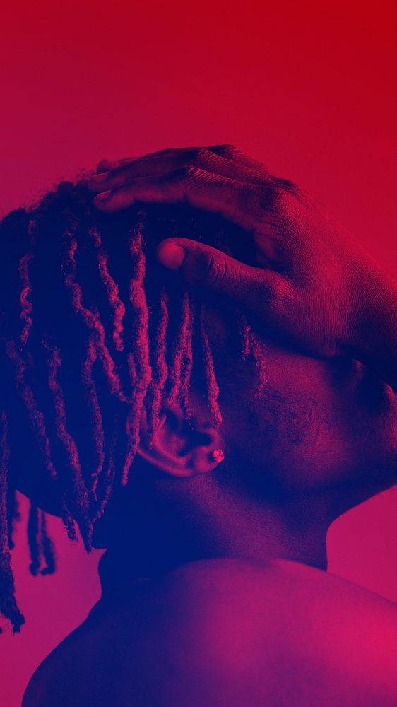 Black man covering his face on a red background