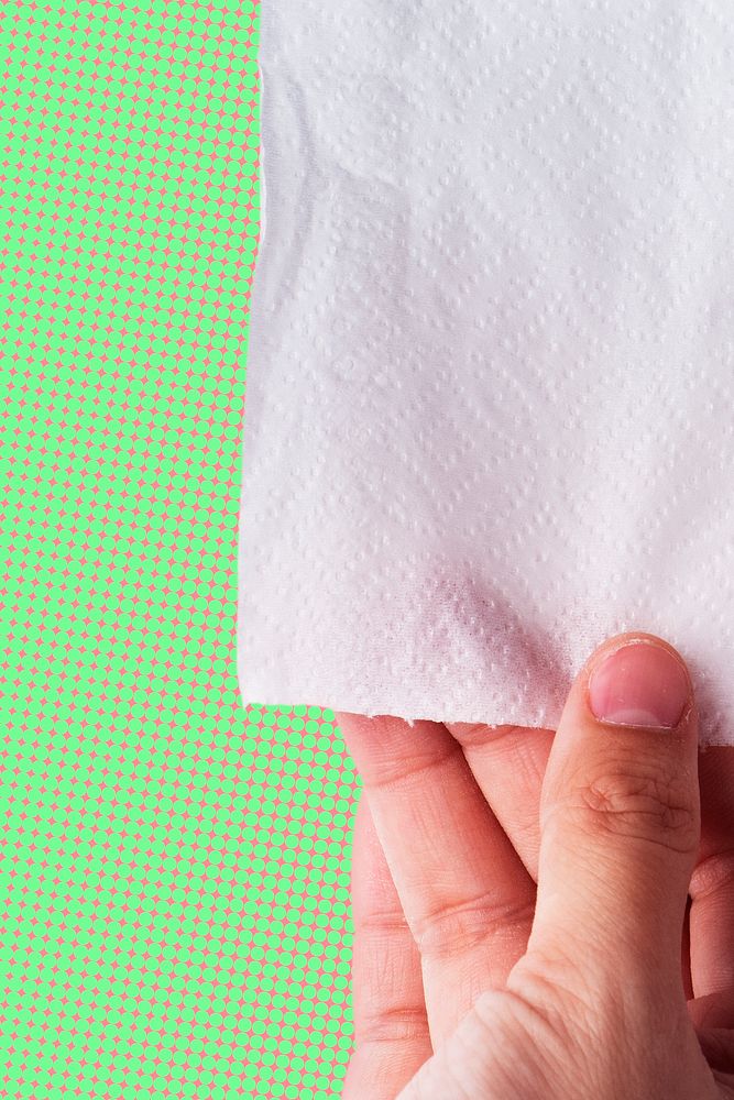 Hand getting toilet paper on pink and green background