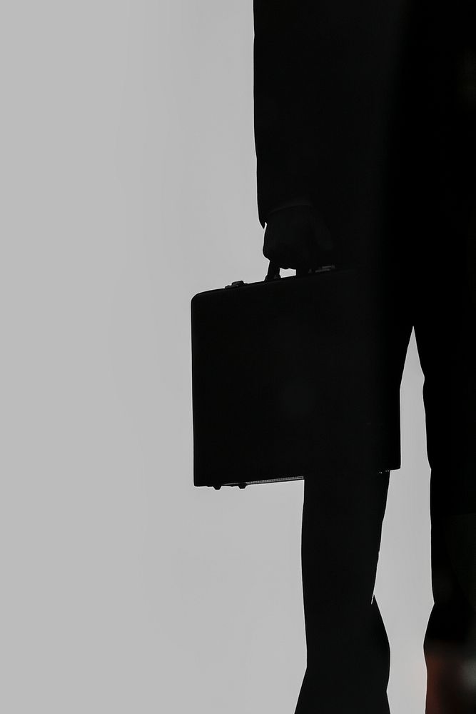 Businessman with a briefcase in the dark