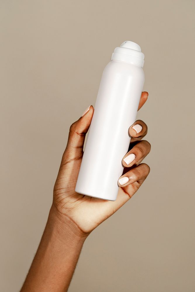 Black woman holding a white spray bottle mockup