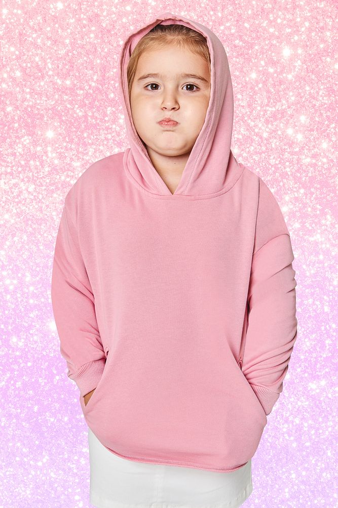 Little cute girl in pink hoodie in studio
