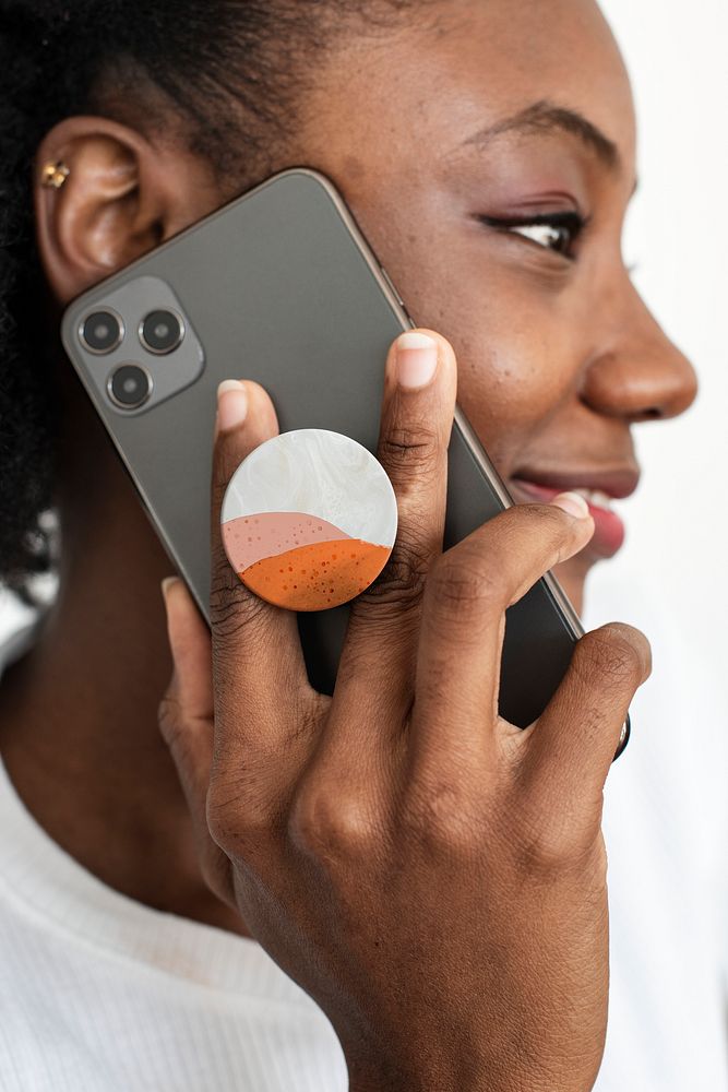Round phone grip behind the mobile with African American woman talking on the phone