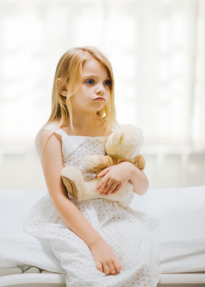 Little girl in hospital holding teddy bear 
