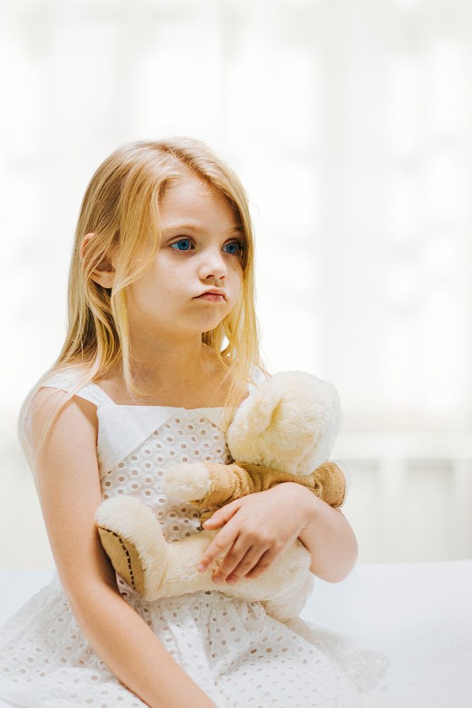 Little girl in hospital, teddy bear background