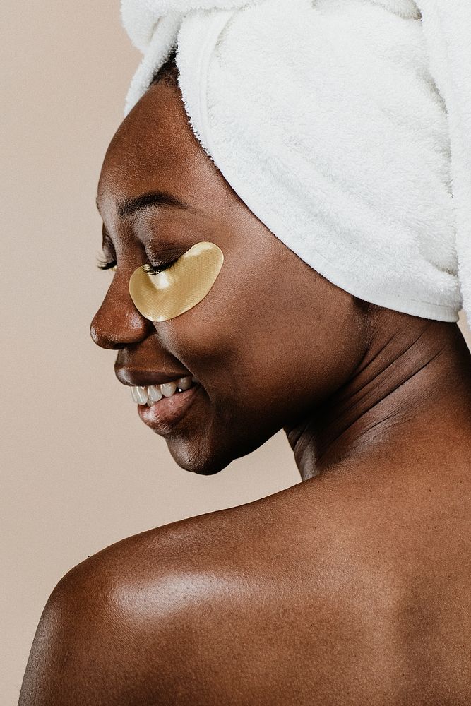 Happy black woman wearing a golden eye mask