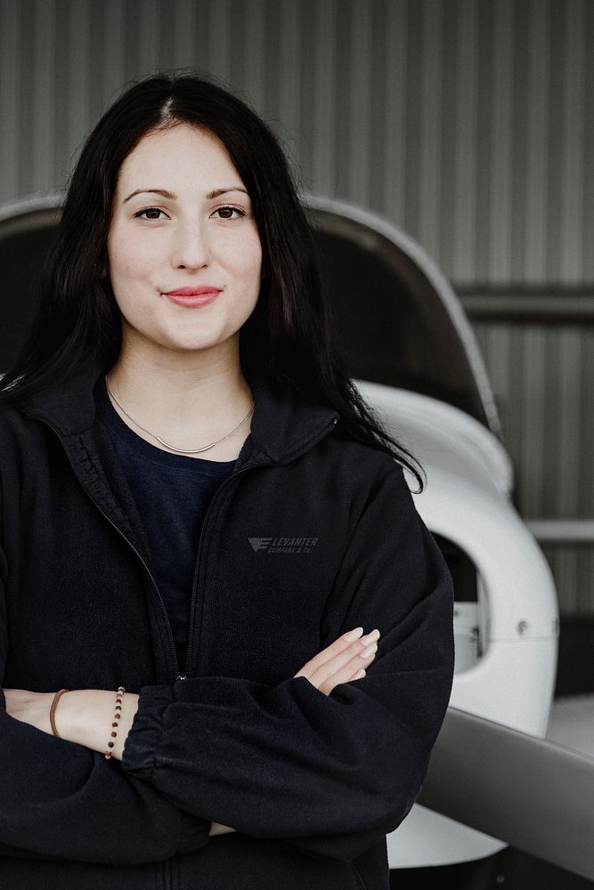 Happy confident airwoman in the hangar