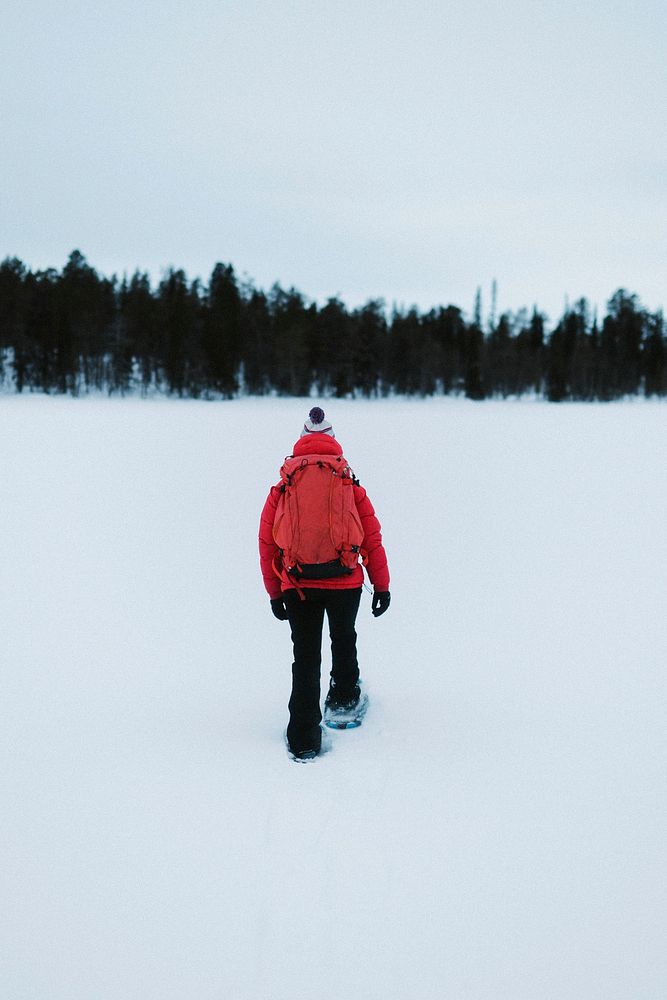 Woman with a backpack trekking in snowshoes