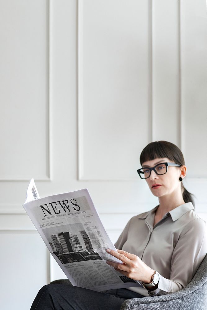 Young businesswoman reading a newspaper