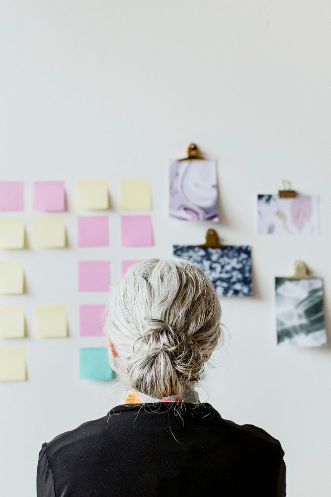 Senior businesswoman brainstorming ideas on a wall