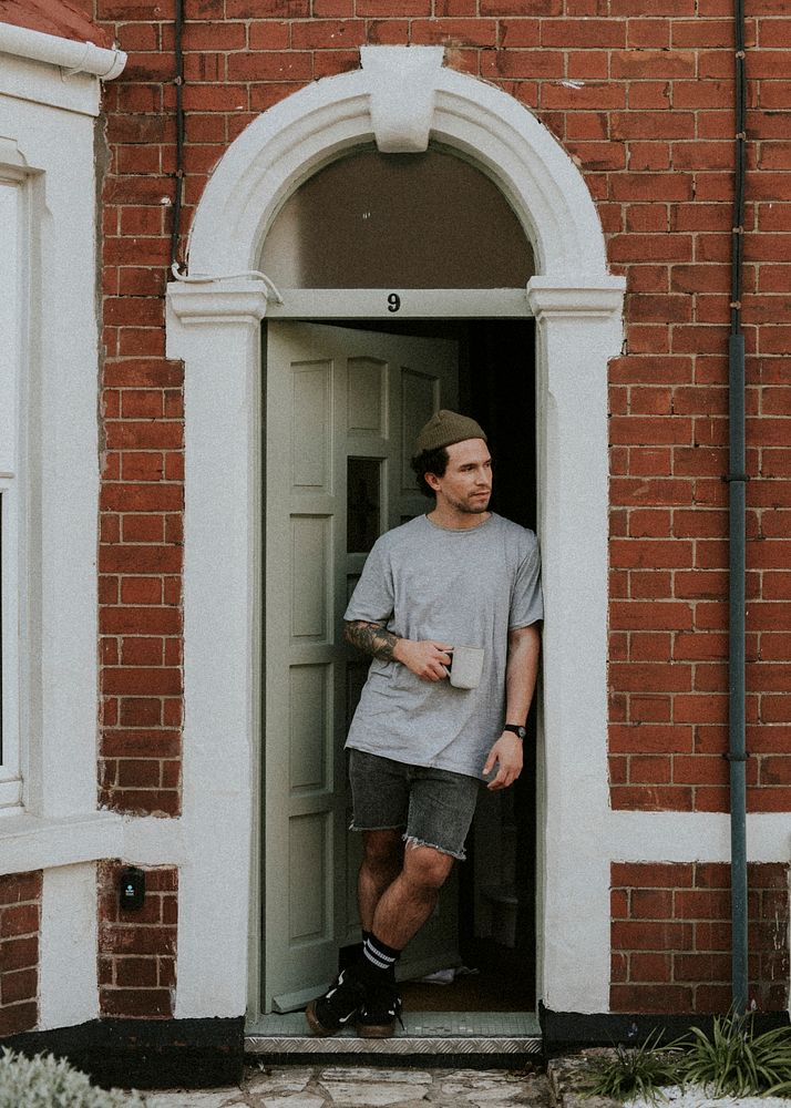 Man having his morning coffee by the doorway of his house during the covid-19 pandemic in Britain. APRIL 5, 2020 - BRISTOL…