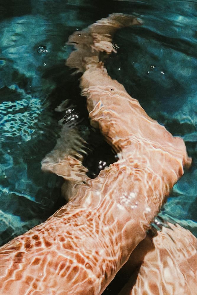 Aesthetic summer vacation photo with legs underwater