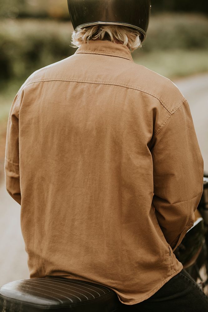Biker in brown shirt jacket with design space rear view