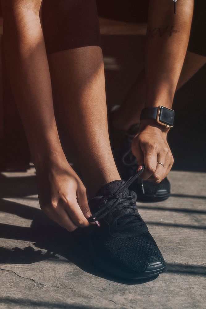 Woman tying her shoelaces, getting ready to exercise 