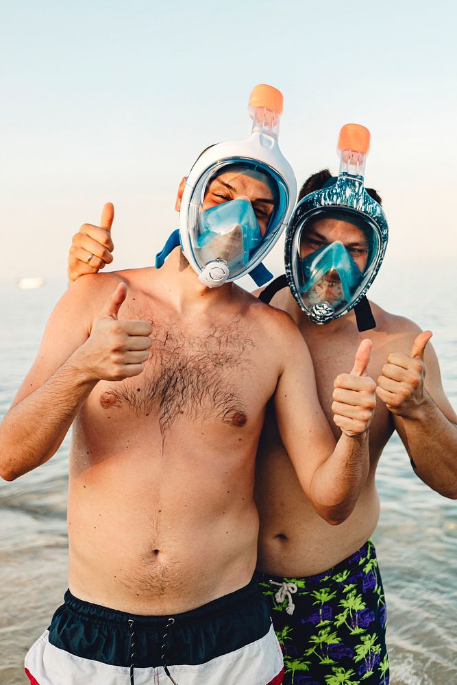 Men wearing full face snorkel mask standing at the beach