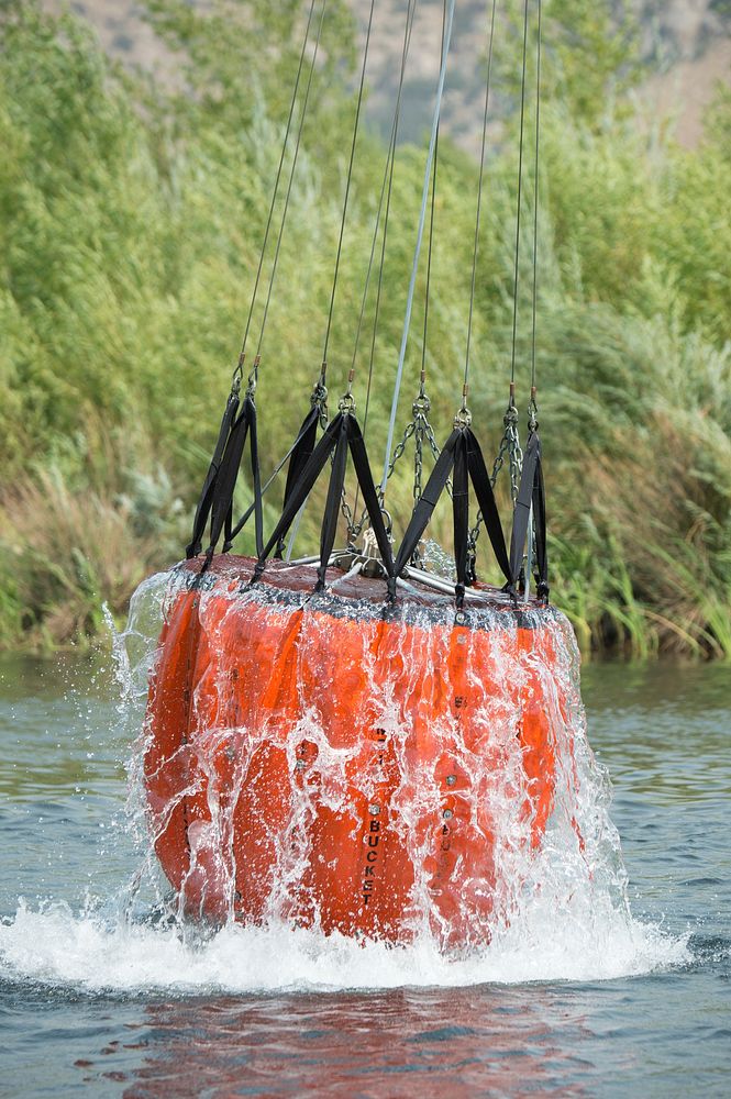 A helicopter uses a "Bambi bucket" to quickly get more than a hundred gallons of water for immediate use on remote areas of…
