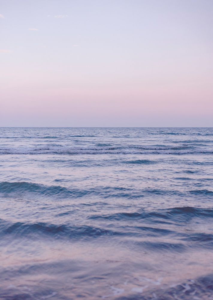 Waves of a purple sea sunset background