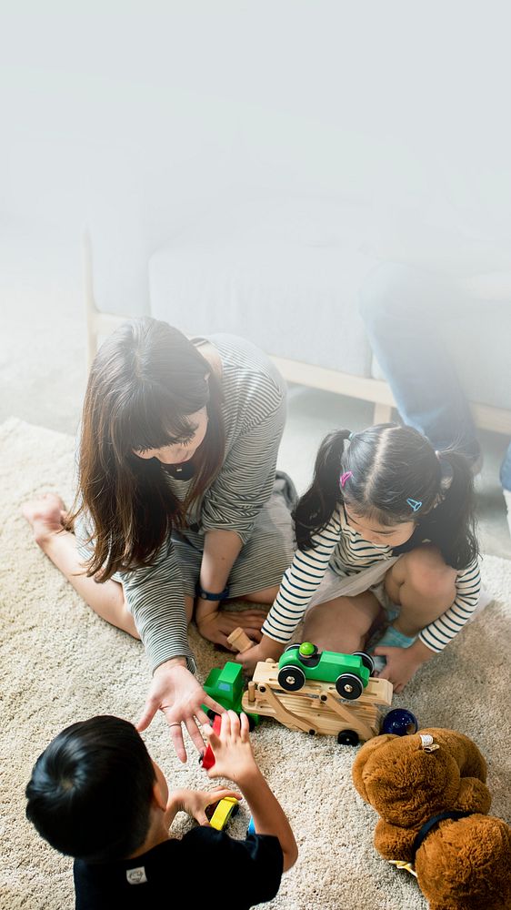Japanese family playing with toys on the floor text space 