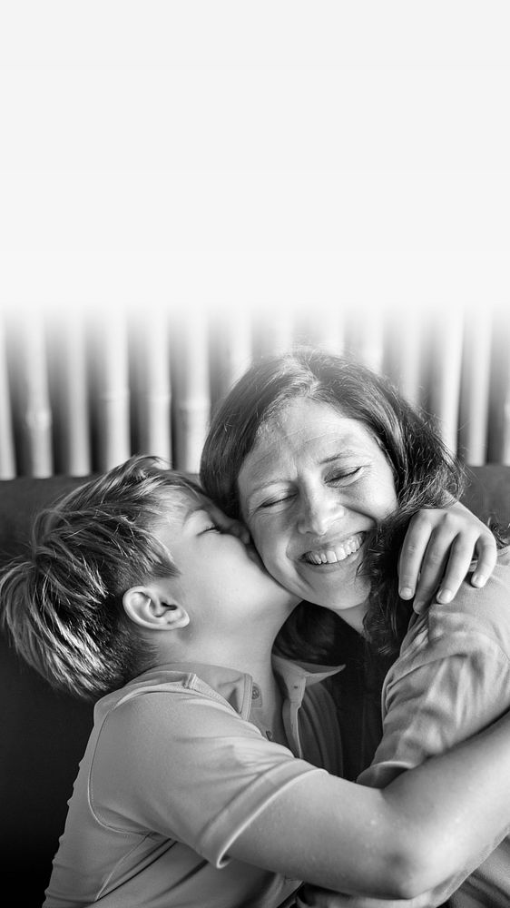 Young boy hugging and kissing his mom blank space
