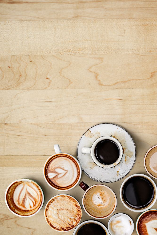 Assorted coffee cups on a light brown wooden board