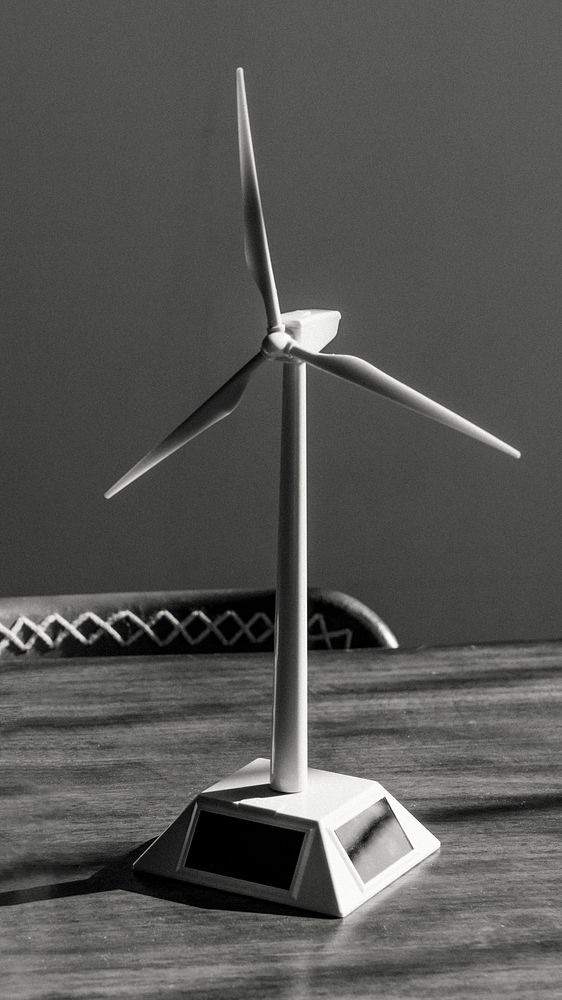 Solar wind turbine model on a wooden table grayscale
