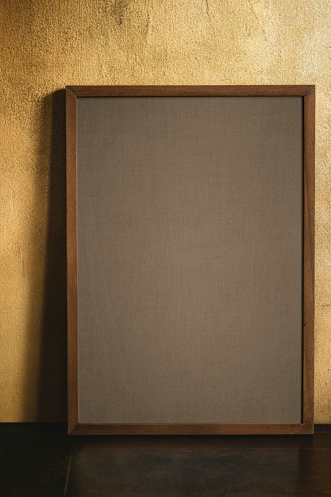 Blank wooden frame by a grunge yellow wall