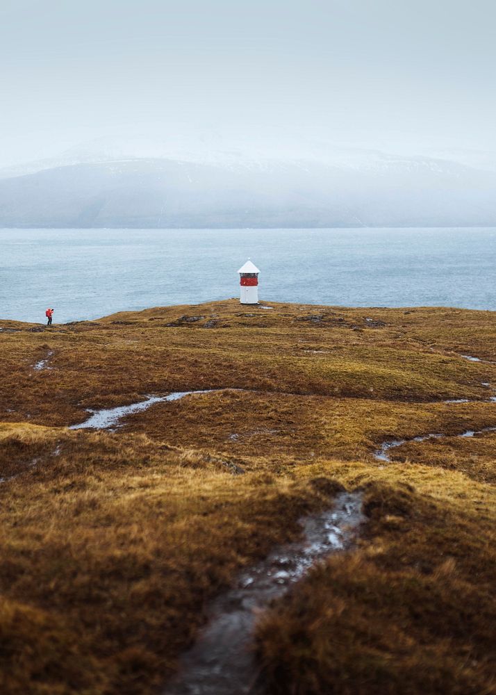 Traveler visiting a lighthouse at the Faroe Islands