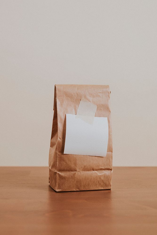 Brown paper bag with a blank white notepaper
