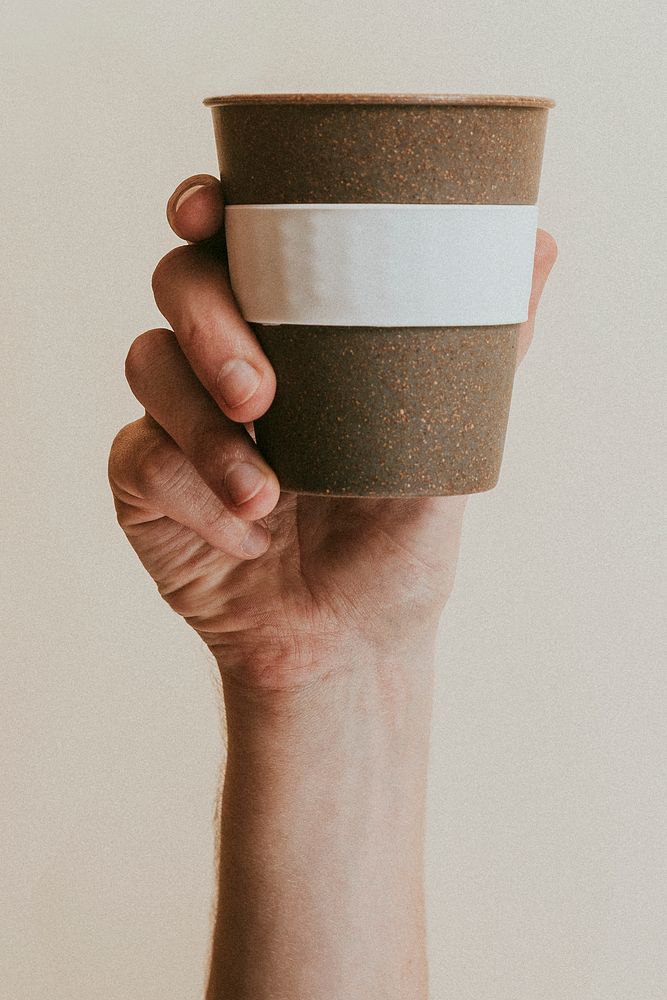 Hand holding a cork reusable cup