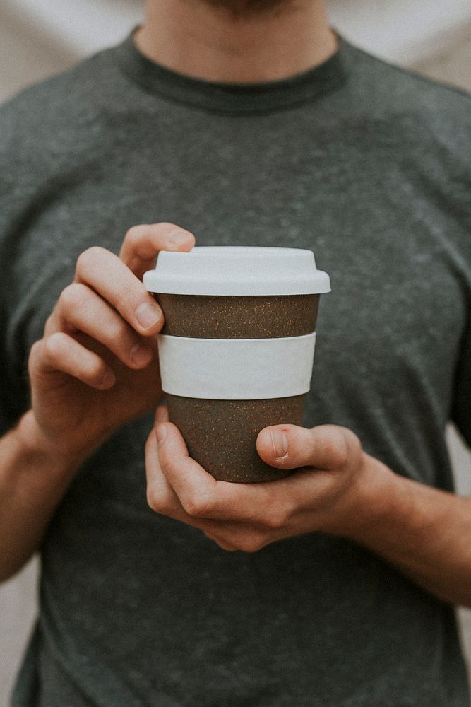 Man holding a brown paper cup