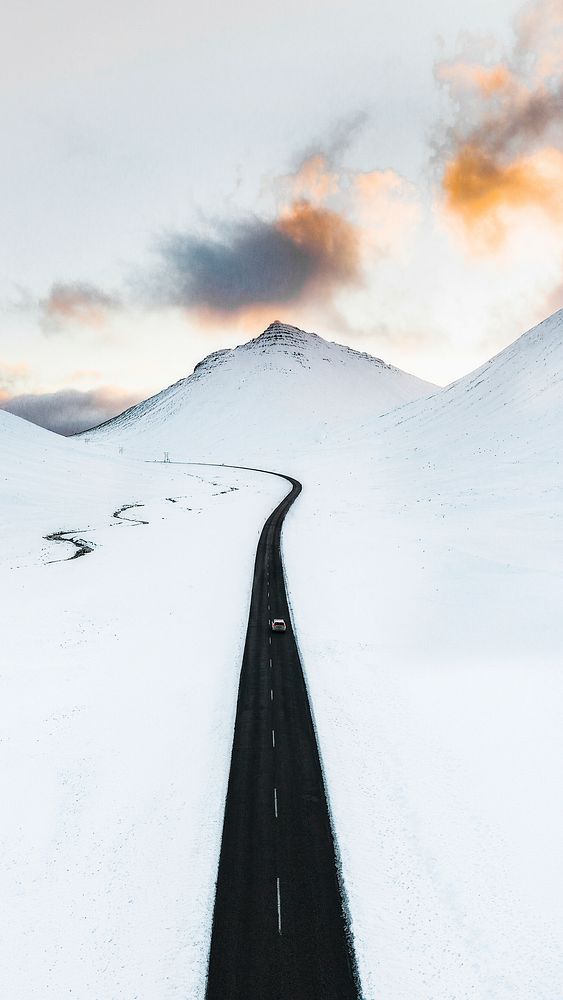 Long black road in the white winter landscape