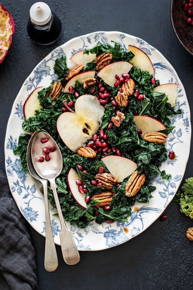 Kale salad with pomegranate and apple with pecans food photography