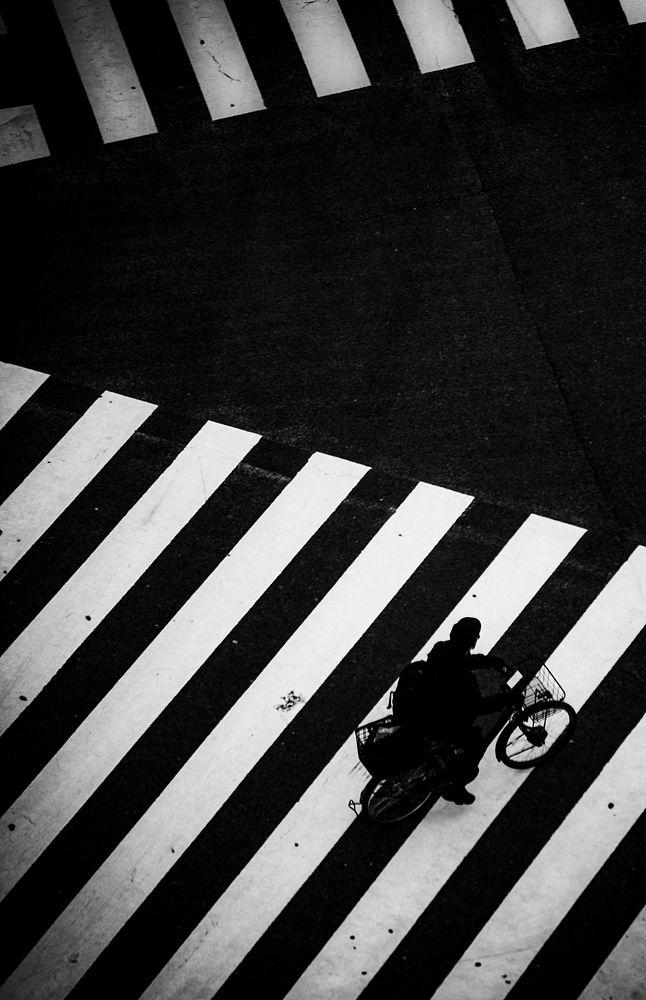 Man riding a bike on a crosswalk in Japan