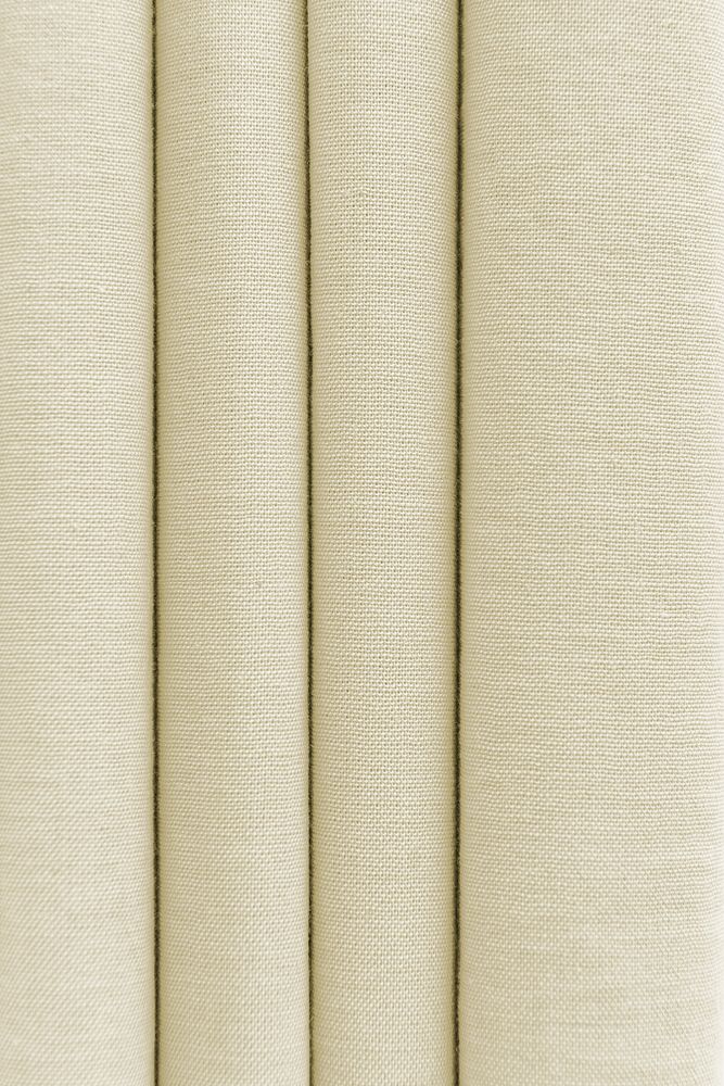 Stack of folded beige woven fabric textured background