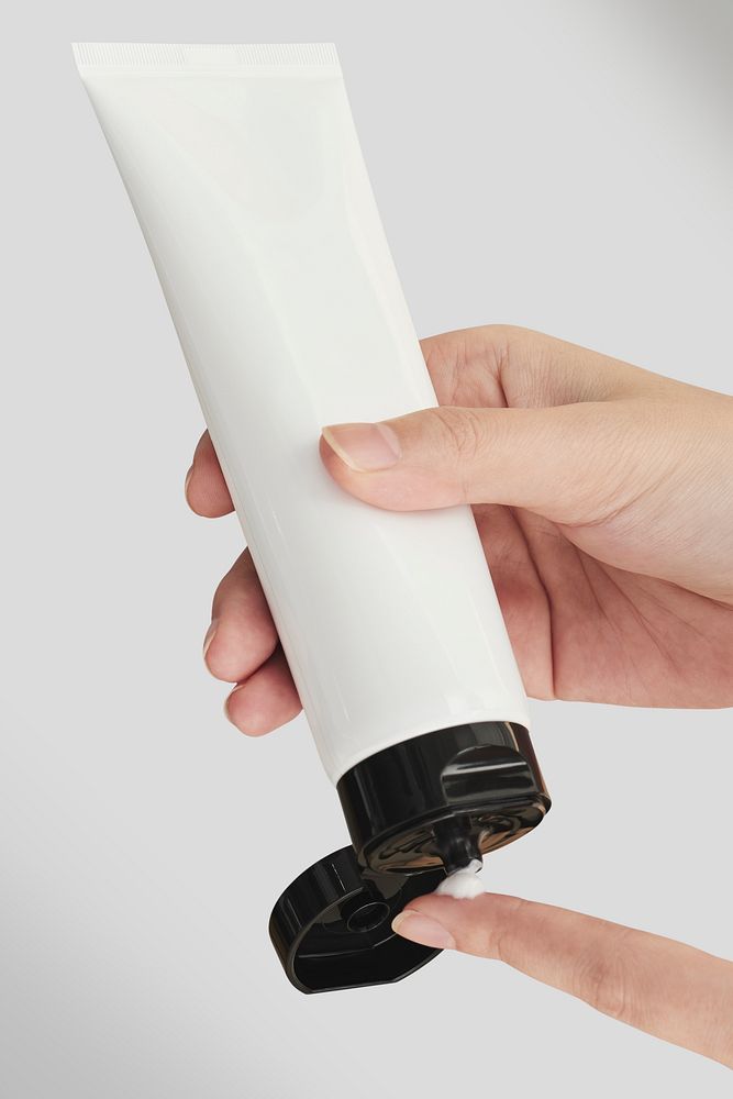 Woman squeezing cream from an unlabeled mockup tube