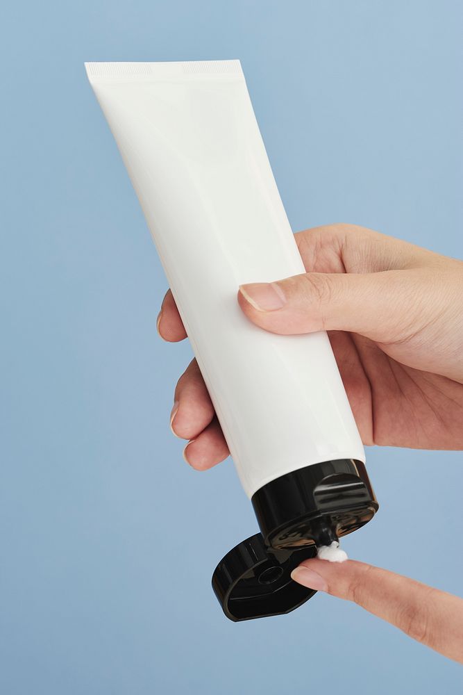 Woman squeezing cream from an unlabeled tube