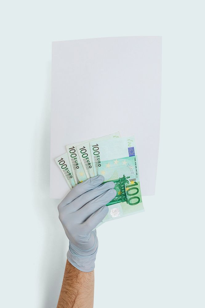 Gloved hand holding a blank paper with banknotes mockup