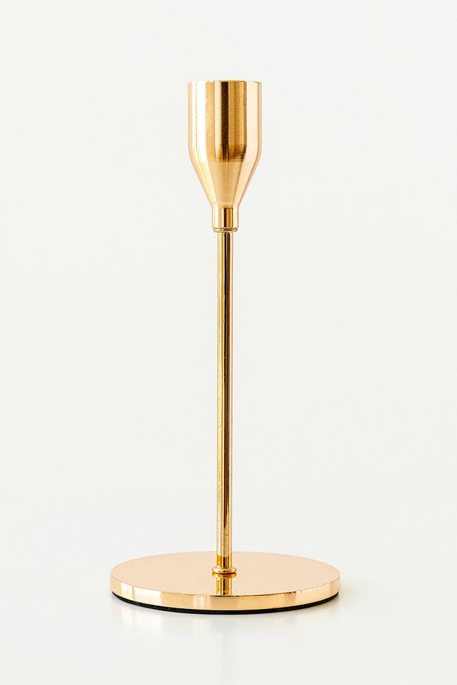 Antique shiny gold candle holder on off white background