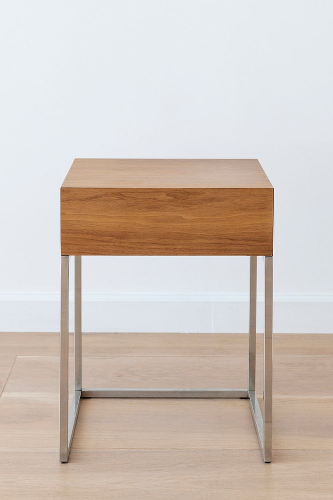 Square wooden stool with metal legs a wooden floor