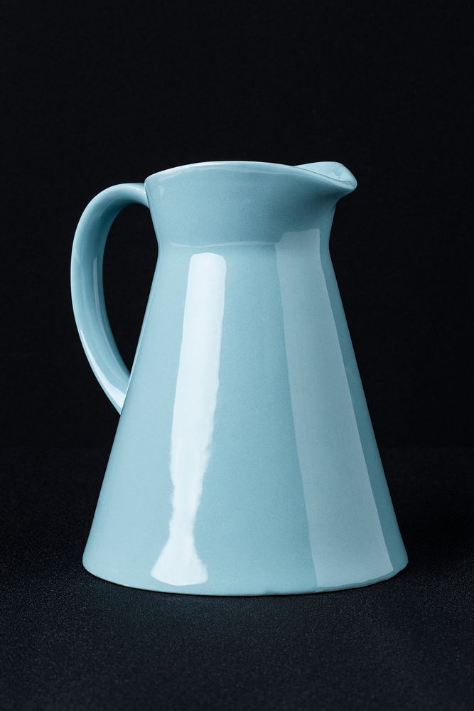 Blue ceramic pitcher on black background