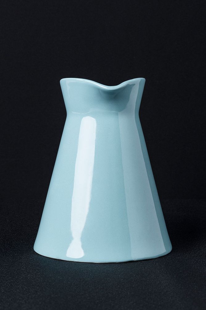 Blue ceramic pitcher on black background