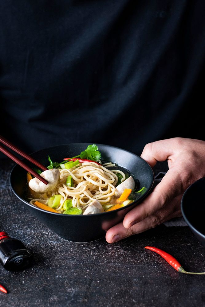 Authentic Asian noodle soup in a black bowl