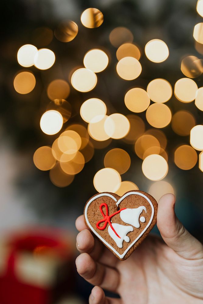 Man holding a heart-shaped gingerbread cookie