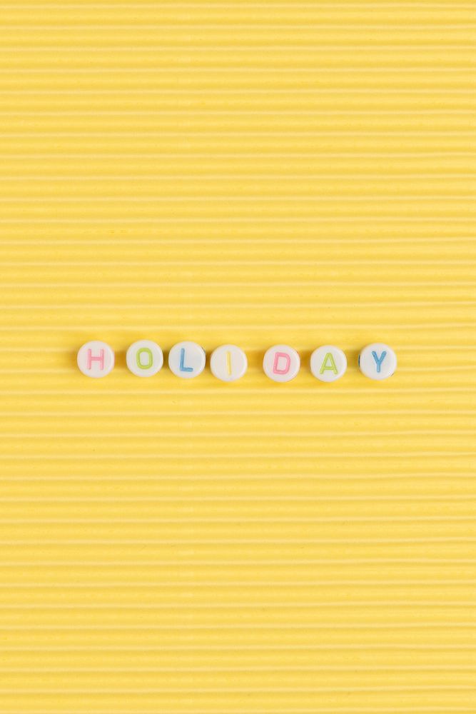 Holiday word beads alphabet yellow background
