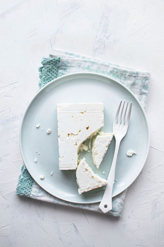 Feta cheese on a  white plate with fork flat lay